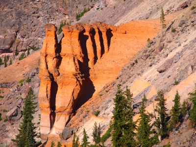 [Rock shaped like stacked hourglasses sticking out from the caldera wall. Rock is bright orange.]